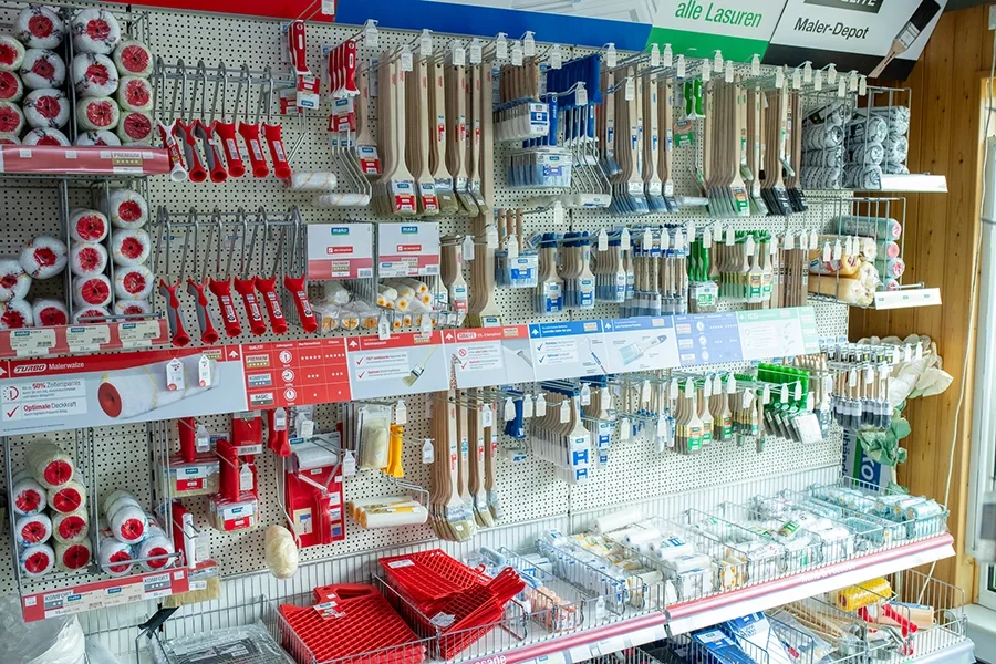 Verschiedene Pinsel und Malerzubehör im Baumarkt-Regal