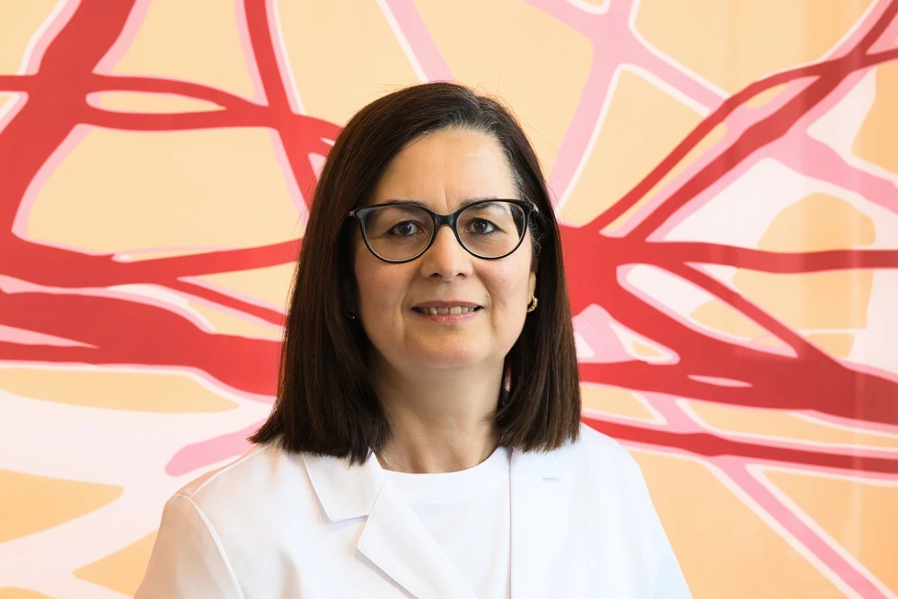 Dr. Larbi im weißen Kittel vor farbigem Hintergrund