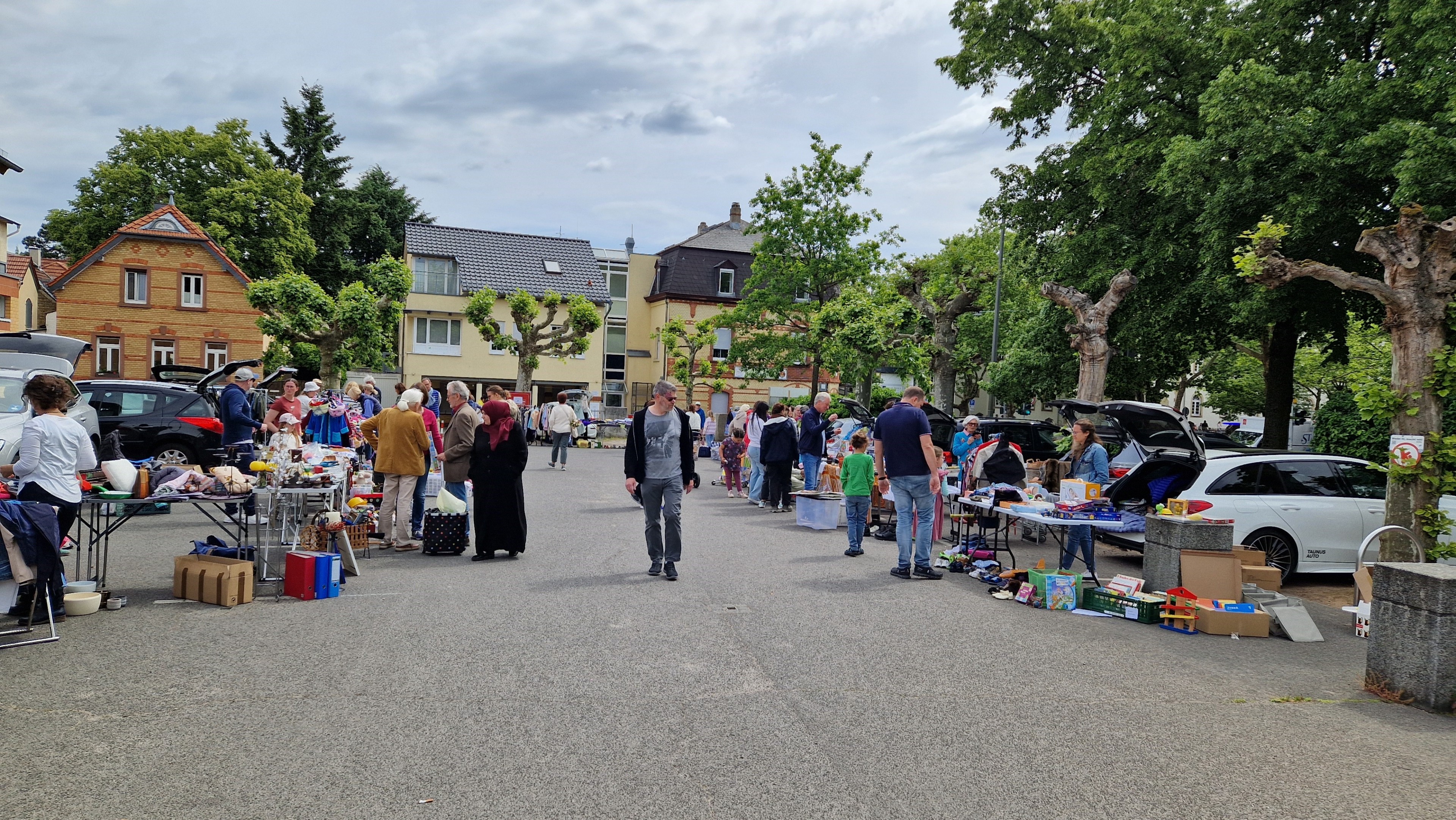 Flohmarkt auf einer Straße mit Menschen, die an Verkaufsständen stöbern