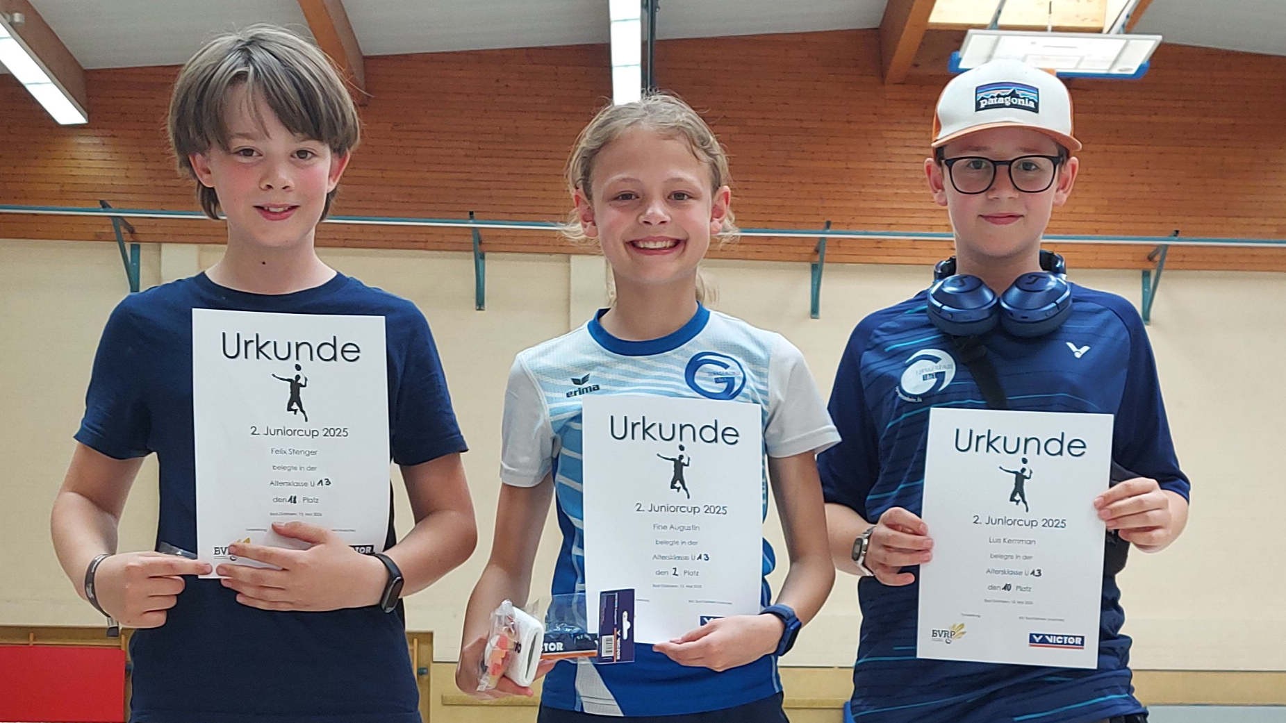 Drei Jugendliche mit Urkunden auf einer Siegerehrung beim Juniorcup 2025