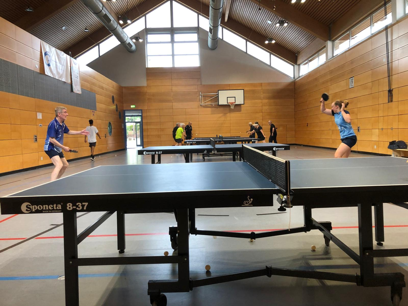Tischtennis-Spieler in einer Sporthalle beim Turnier.