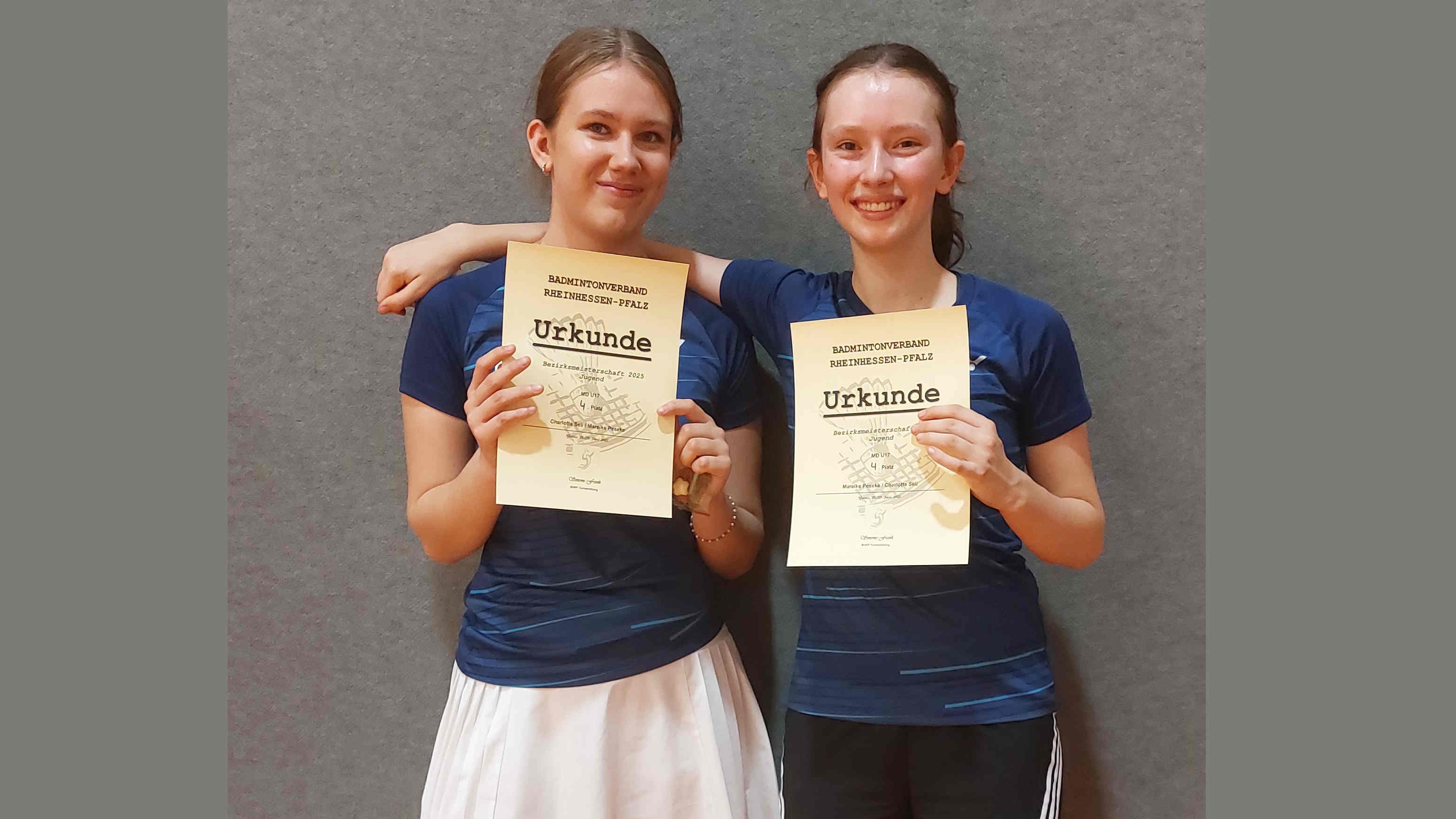 Zwei junge Frauen halten Urkunden vom Badmintonverband Rheinhessen-Pfalz