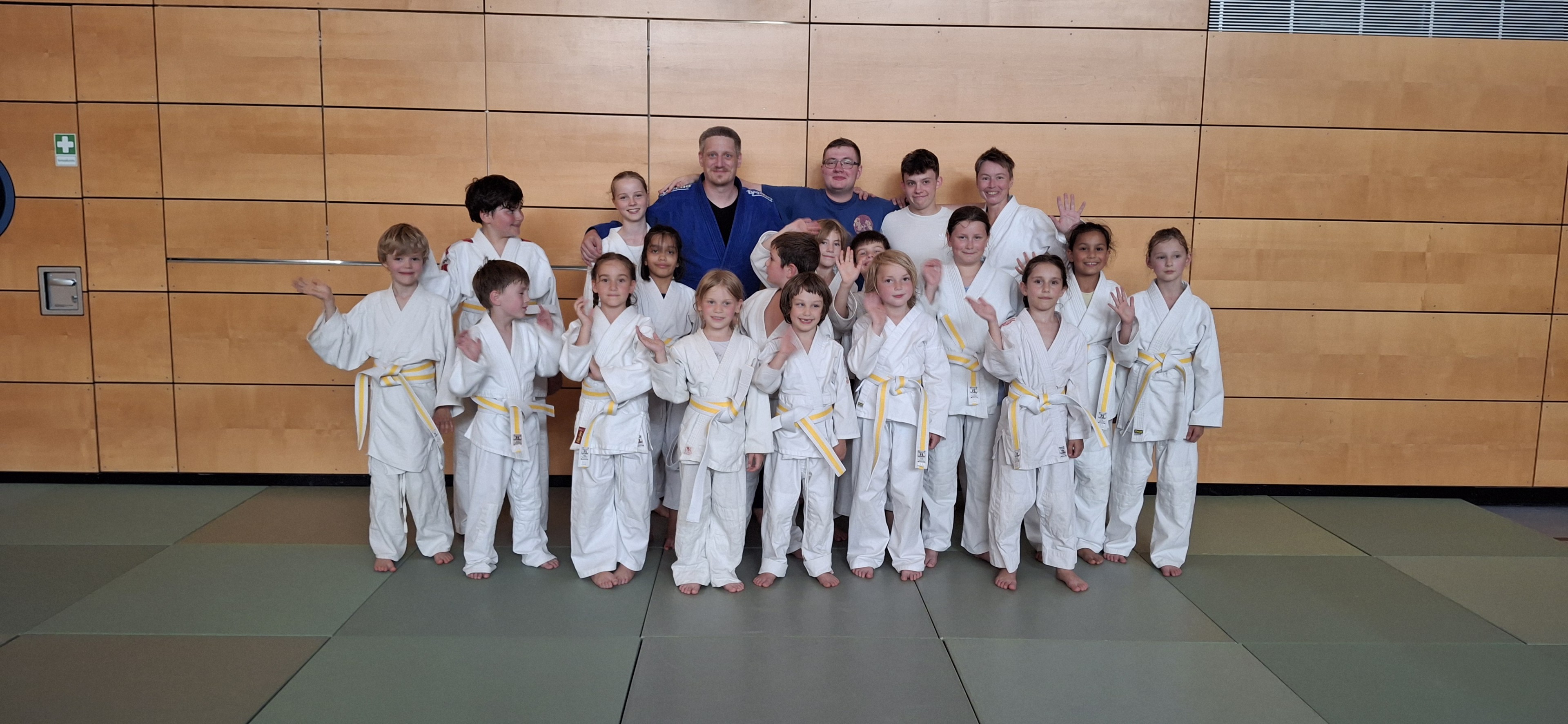 Gruppe von Kindern und Trainern in Judo-Gi