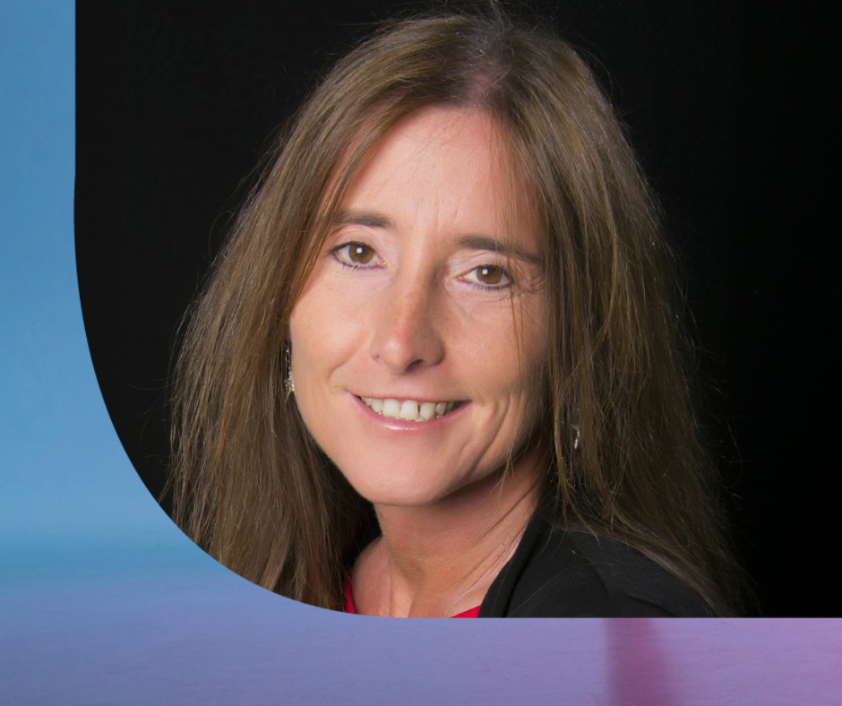 Porträt einer lächelnden Frau mit langen braunen Haaren vor schwarzem Hintergrund