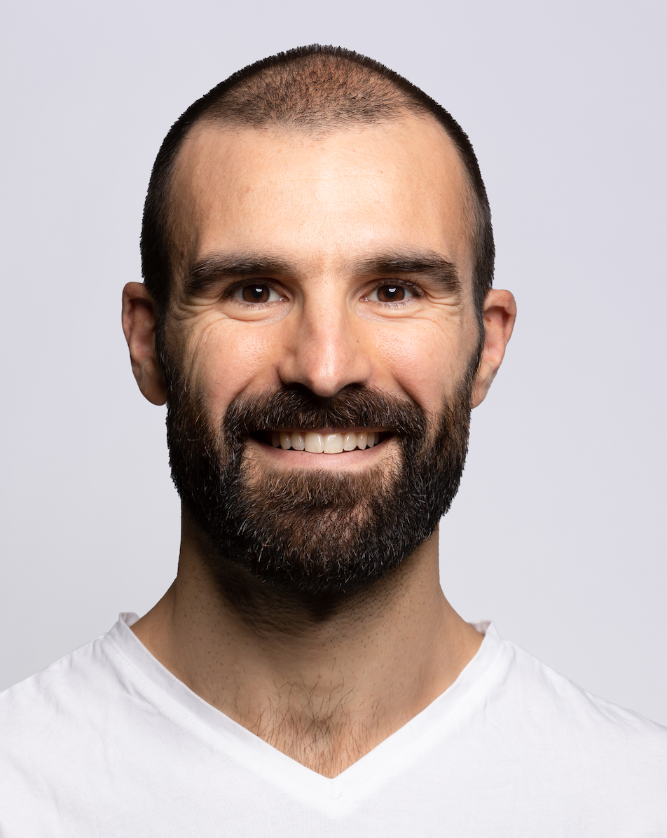 Porträt eines freundlich lächelnden Mannes mit Bart in einem weißen T-Shirt