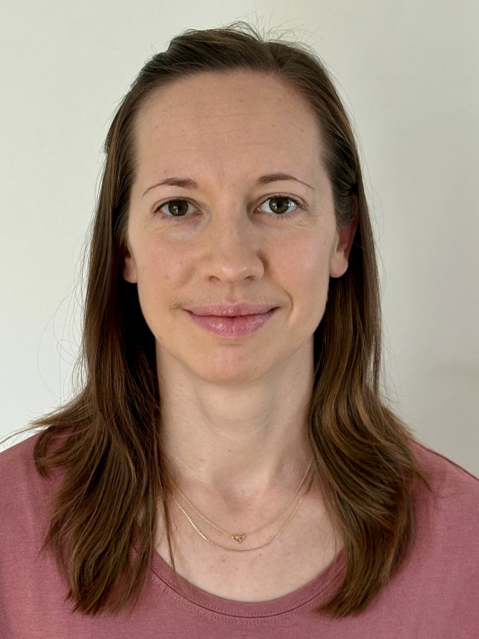 Porträt einer Frau mit braunen Haaren und einem leichten Lächeln