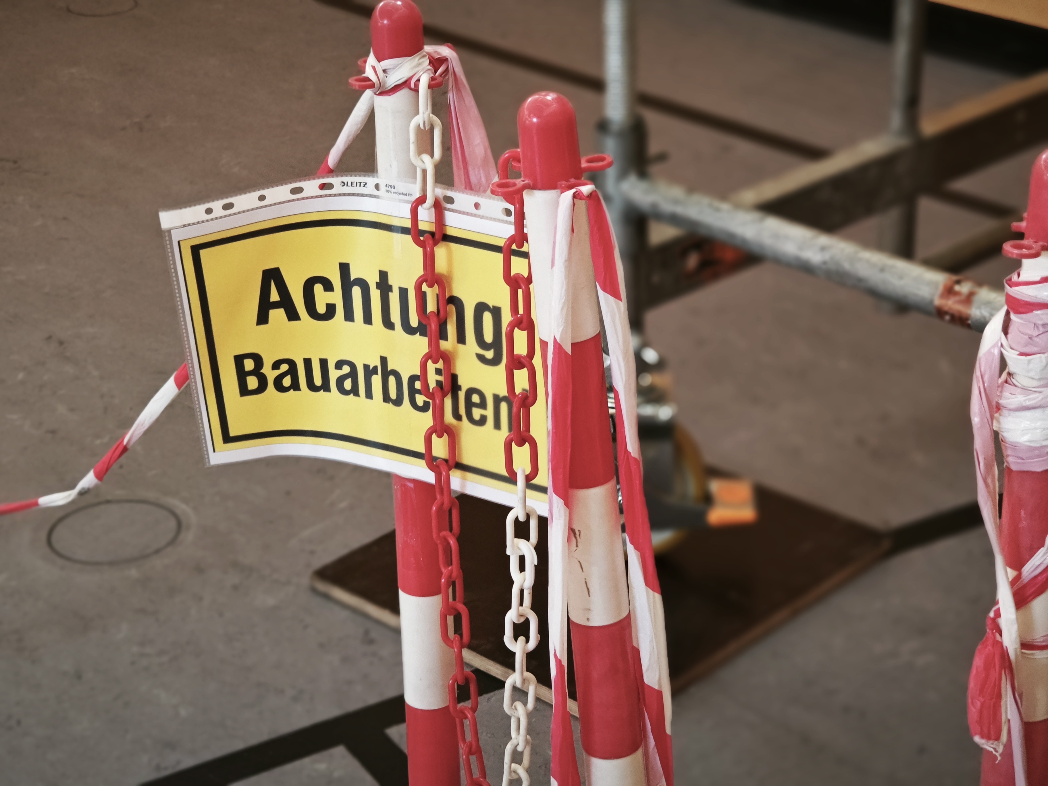 Warnschild Achtung Bauarbeiten mit Absperrung und Ketten auf einer Baustelle