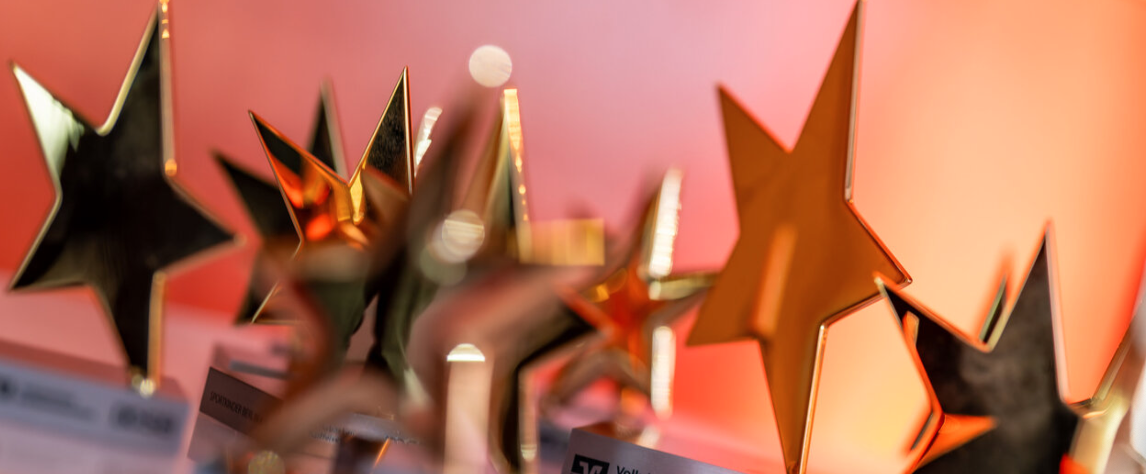 Goldene Sterne als Auszeichnungen vor rotem Hintergrund, aufgenommen am 15. August 2025