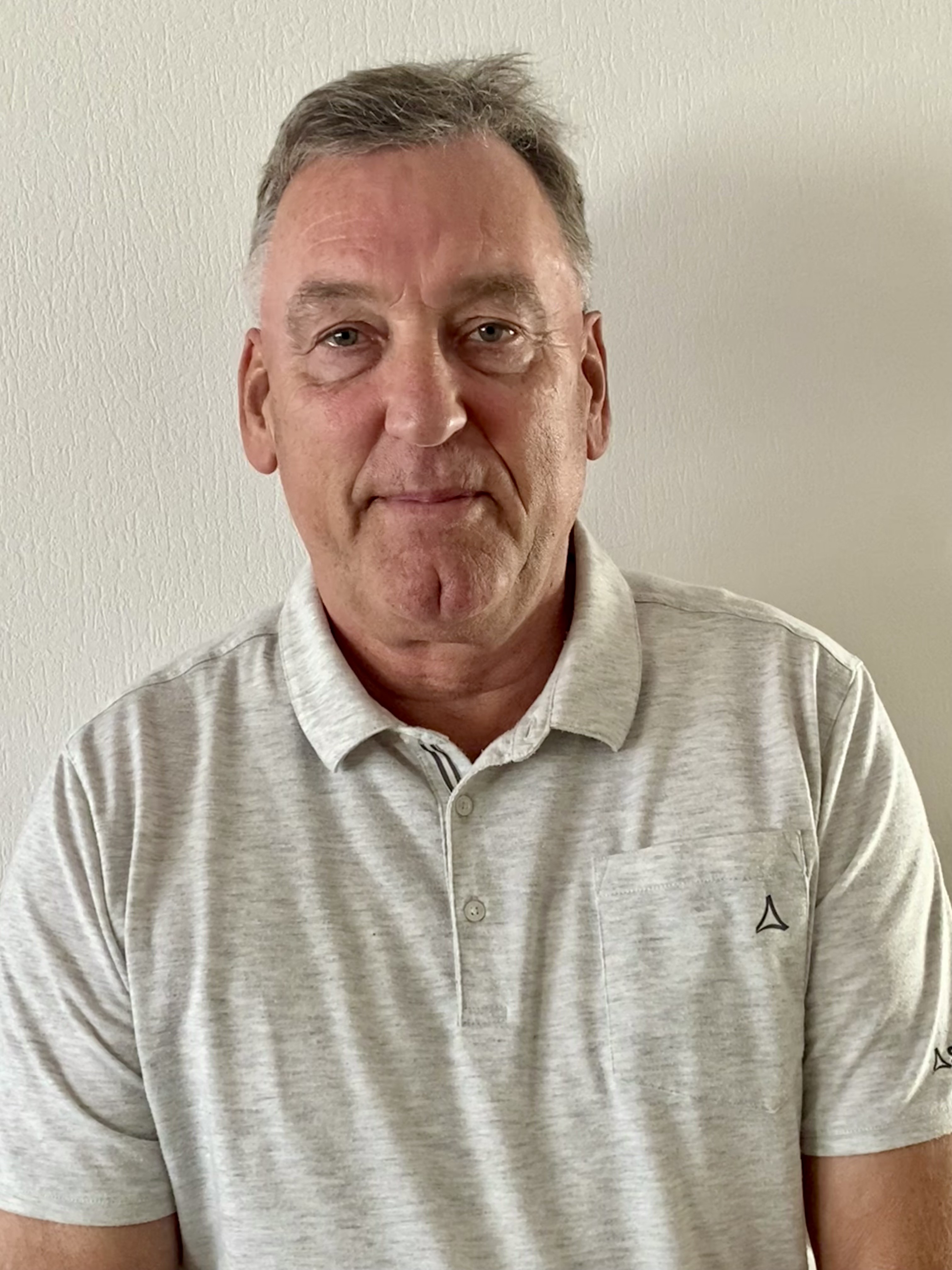 Horst Friedrich mit grauem Poloshirt vor heller Wand