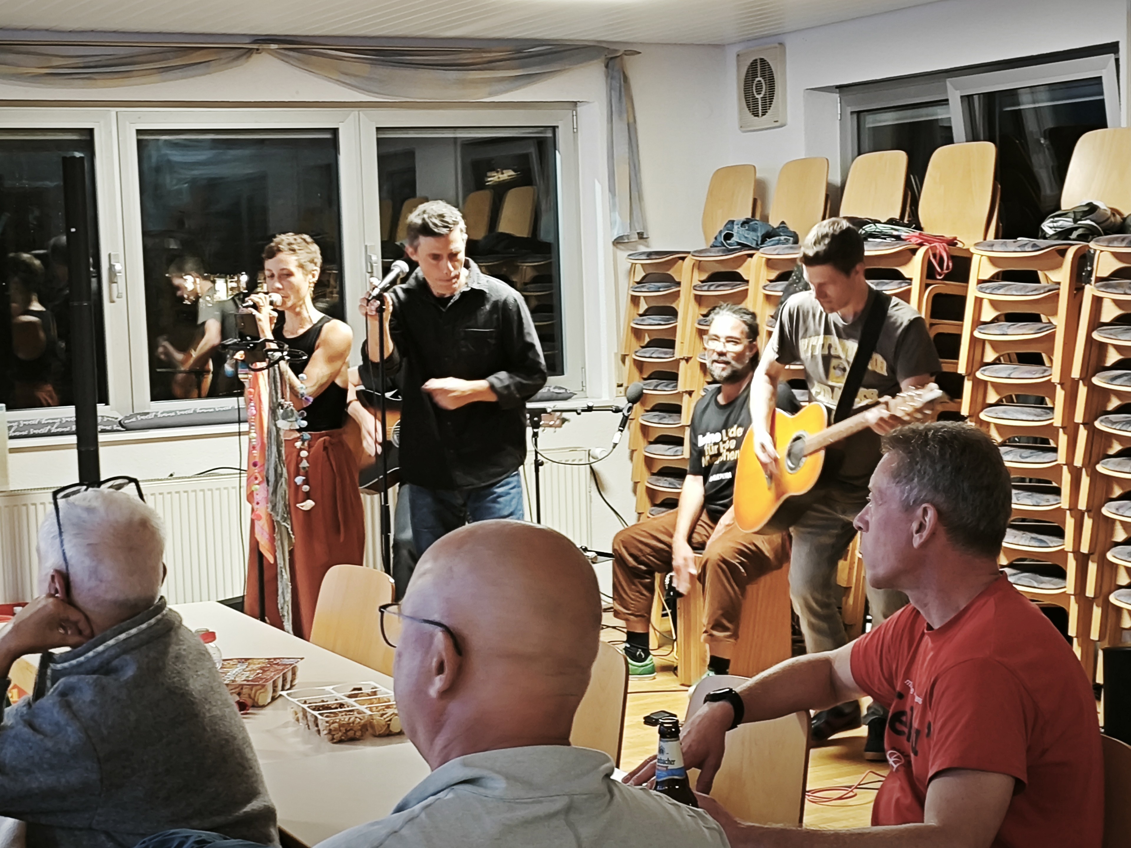 Live Musik-Auftritt bei einer Veranstaltung am 24. September 2025 mit Band und Publikum in einem Gemeinschaftsraum