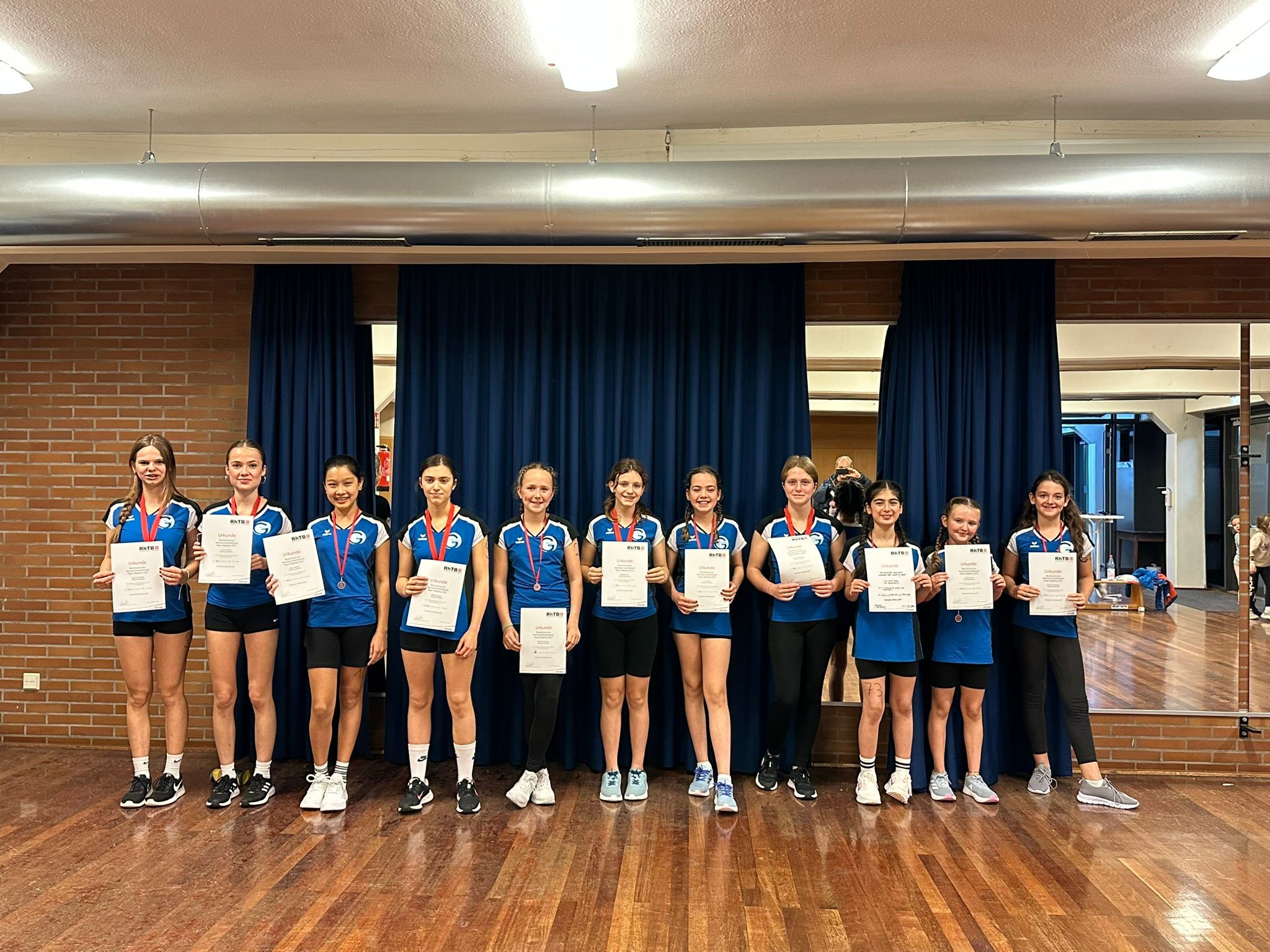 Sportliche Siegerehrung: Mädchenmannschaft mit Urkunden und Medaillen bei einem Wettkampf