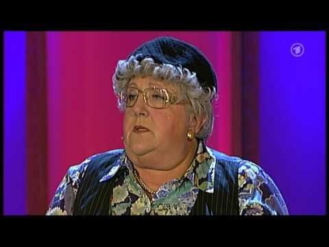 Hildegard auf einer Bühne mit bunter Kleidung und schwarzer Mütze