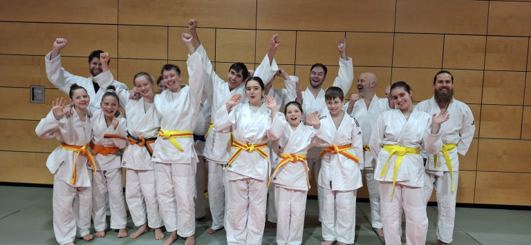 Judo-Gruppe mit gelb-orangen Gürteln beim Training am 15.12.2025 Judo-Gruppe mit Kindern und Jugendlichen in weißen Anzügen und gelb-orangen Gürteln beim Training oder Wettkampf