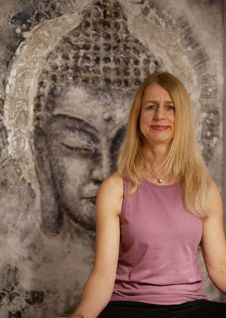 Frau beim Yoga vor Buddha-Wandbild