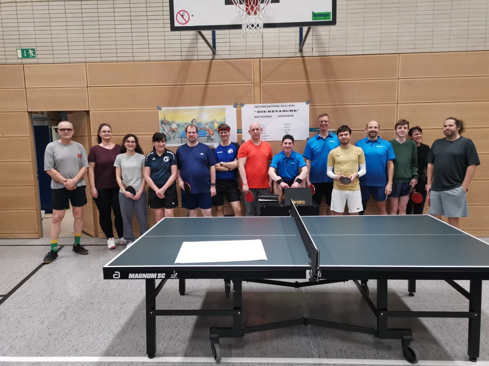 Gruppenbild von Tischtennisspielern in einer Sporthalle vor einer Tischtennisplatte