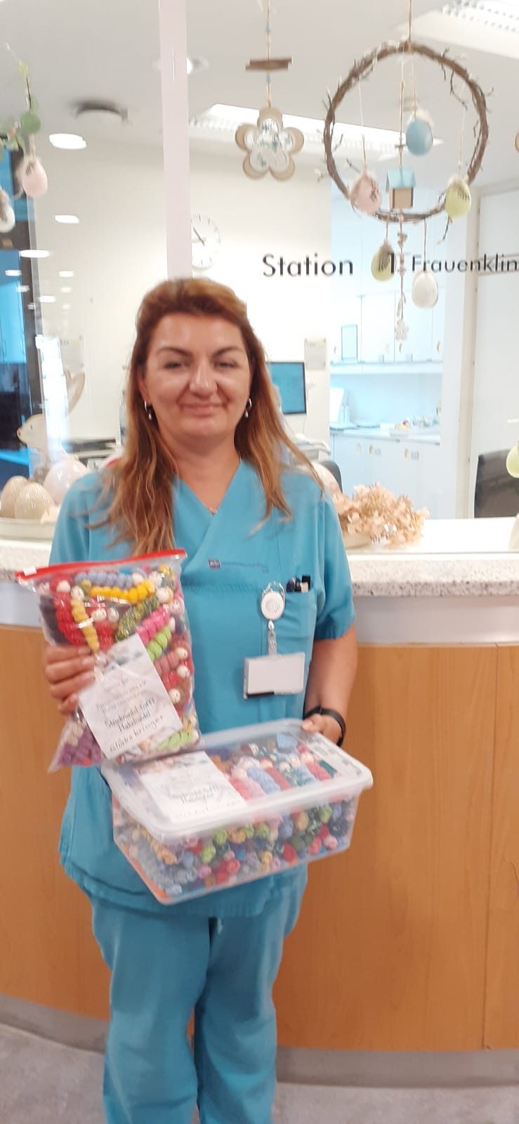 Krankenschwester hält bunte Perlenketten als Geschenk im Krankenhaus