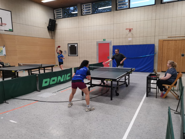 Tischtennis Einzelspiel in einer Sporthalle mit zwei Spielern am Tisch