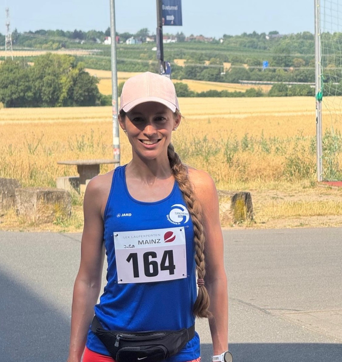 Julia beim GemeinZamkeit Spendenlauf in Mainz, Teilnehmerin mit Startnummer 164 vor sommerlicher Landschaft