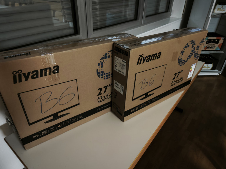 Zwei iiyama ProLite XU2793HSU 27 Zoll Monitore in Originalverpackung auf einem Tisch