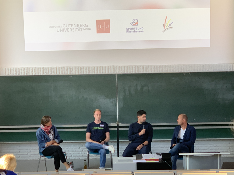 Podiumsdiskussion an der Johannes Gutenberg-Universität Mainz mit Teilnehmern vor einer Tafel, veranstaltet vom Sportbund Rheinhessen
