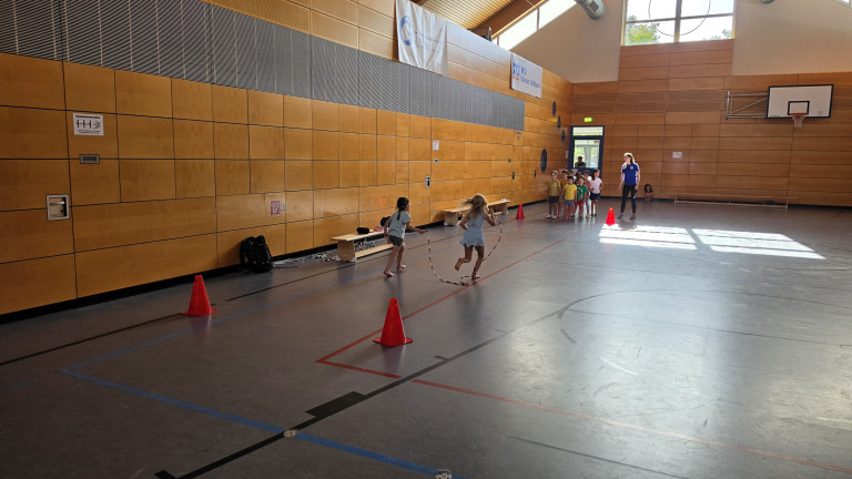 Kinder beim Sport in der Turnhalle am 07.09.2026 Kinder spielen mit Springseil in einer Turnhalle am 07.09.2026