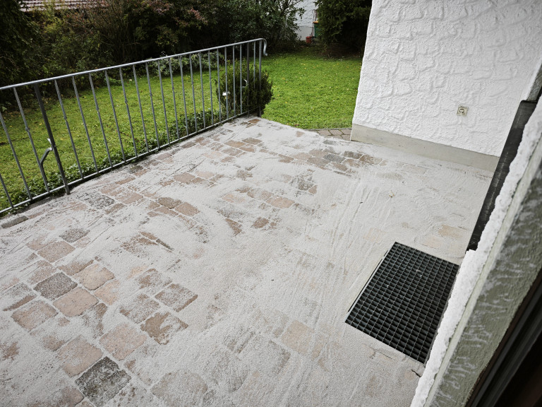 Frisch verfugte Terrasse mit Pflastersteinen und Gartenansicht Terrasse mit frisch verfugtem Pflaster und Blick auf Garten