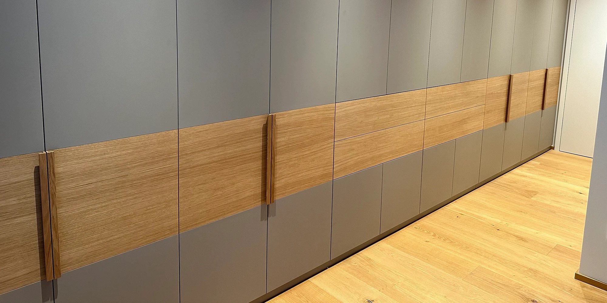 Moderner Einbauschrank mit Holz- und Grauelementen als Header-Schrank