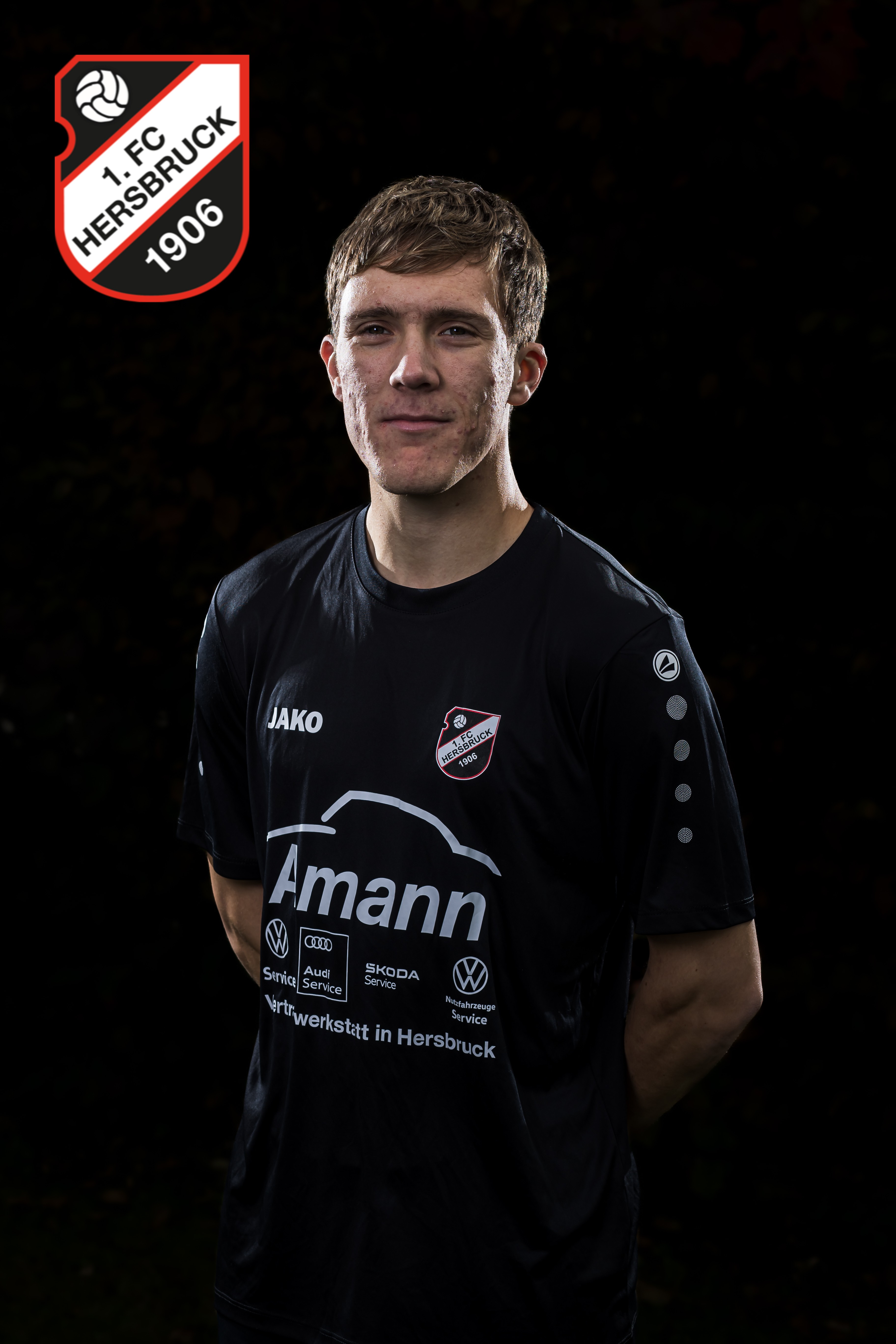 Spieler des 1. FC Hersbruck 1906 im schwarzen JAKO-Trikot mit Amann-Werbung