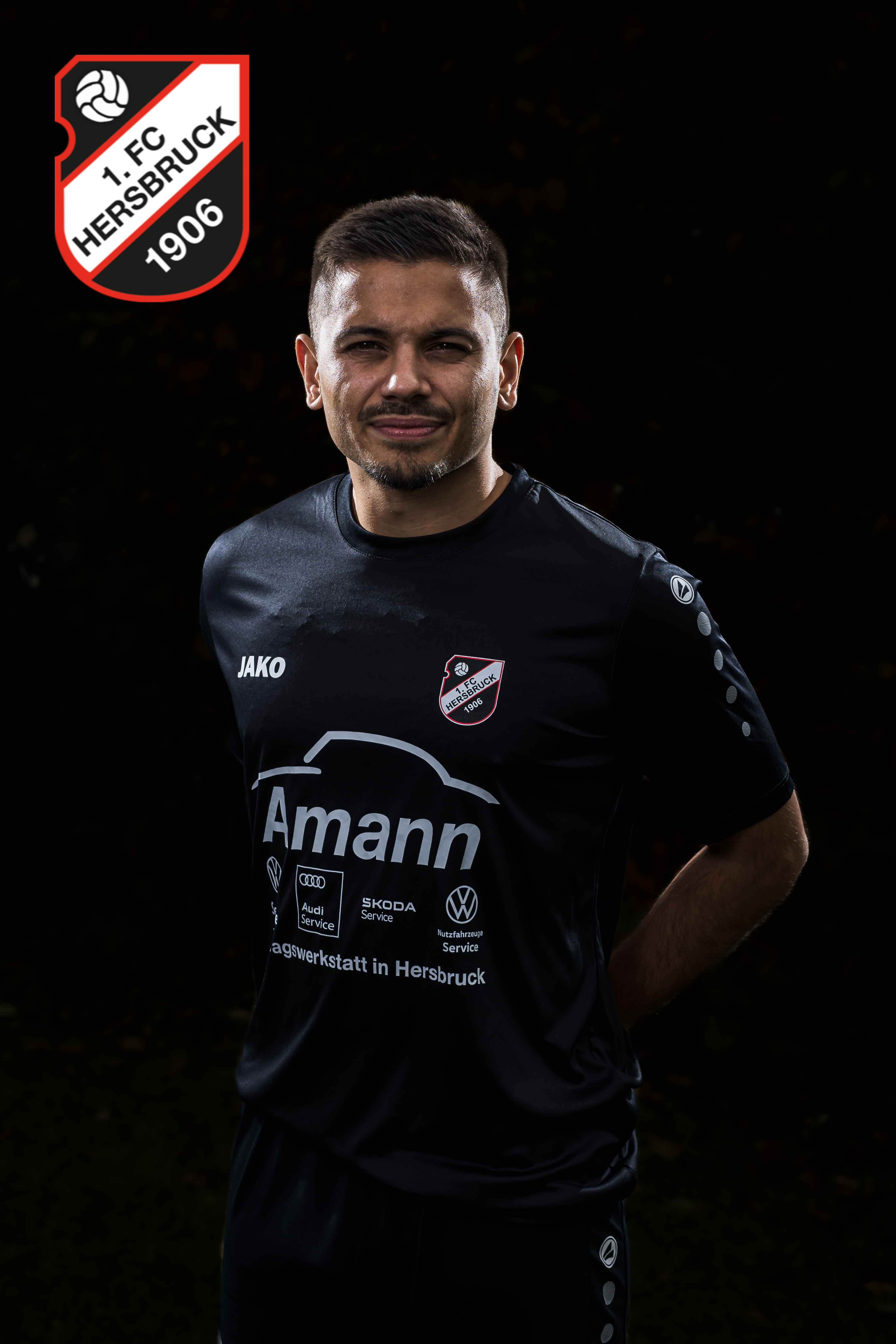 Fußballspieler des 1. FC Hersbruck 1906 im schwarzen Jako-Trikot mit Amann-Werbung