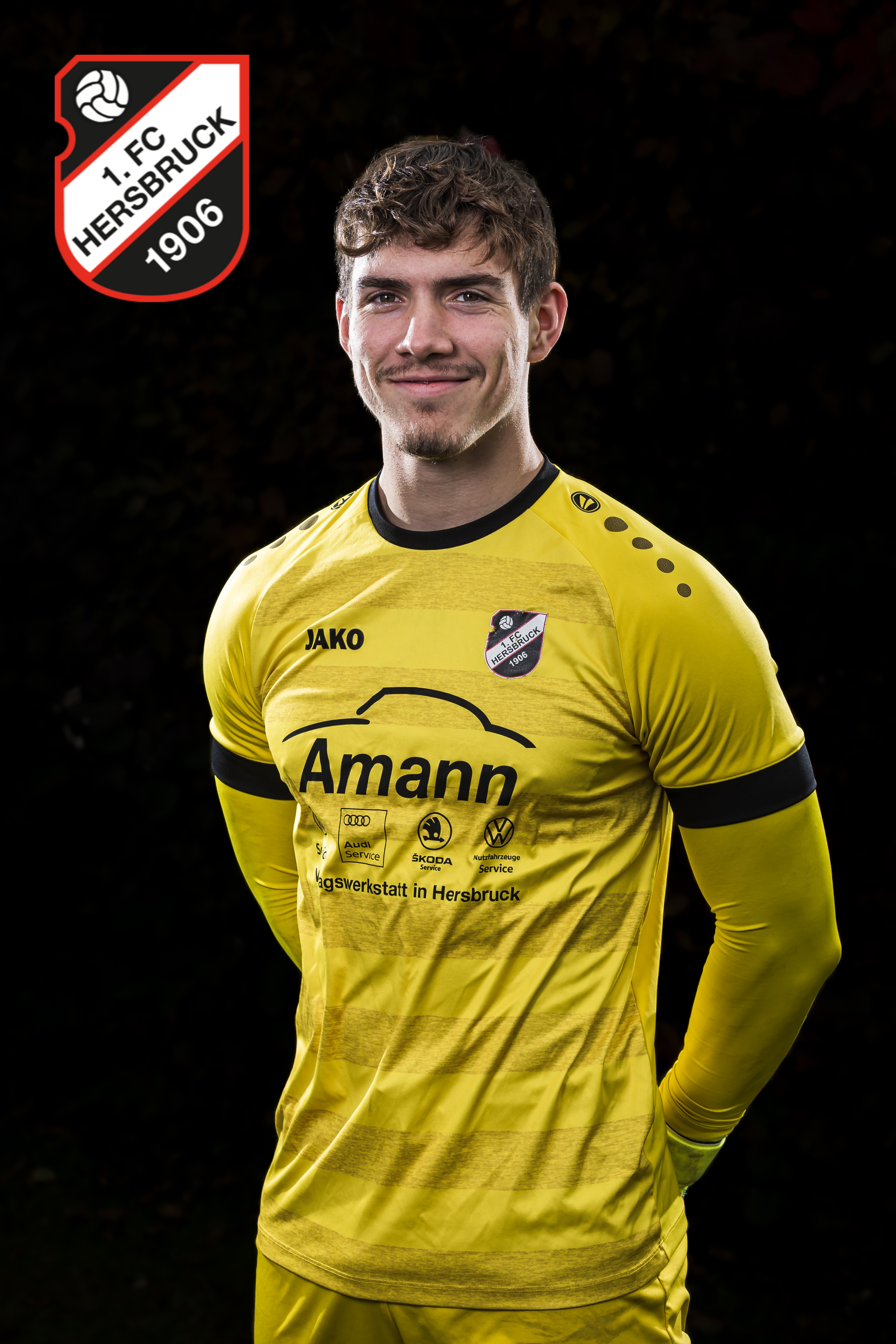 Fußballspieler des 1. FC Hersbruck 1906 im gelben Trikot von JAKO mit Amann-Werbung