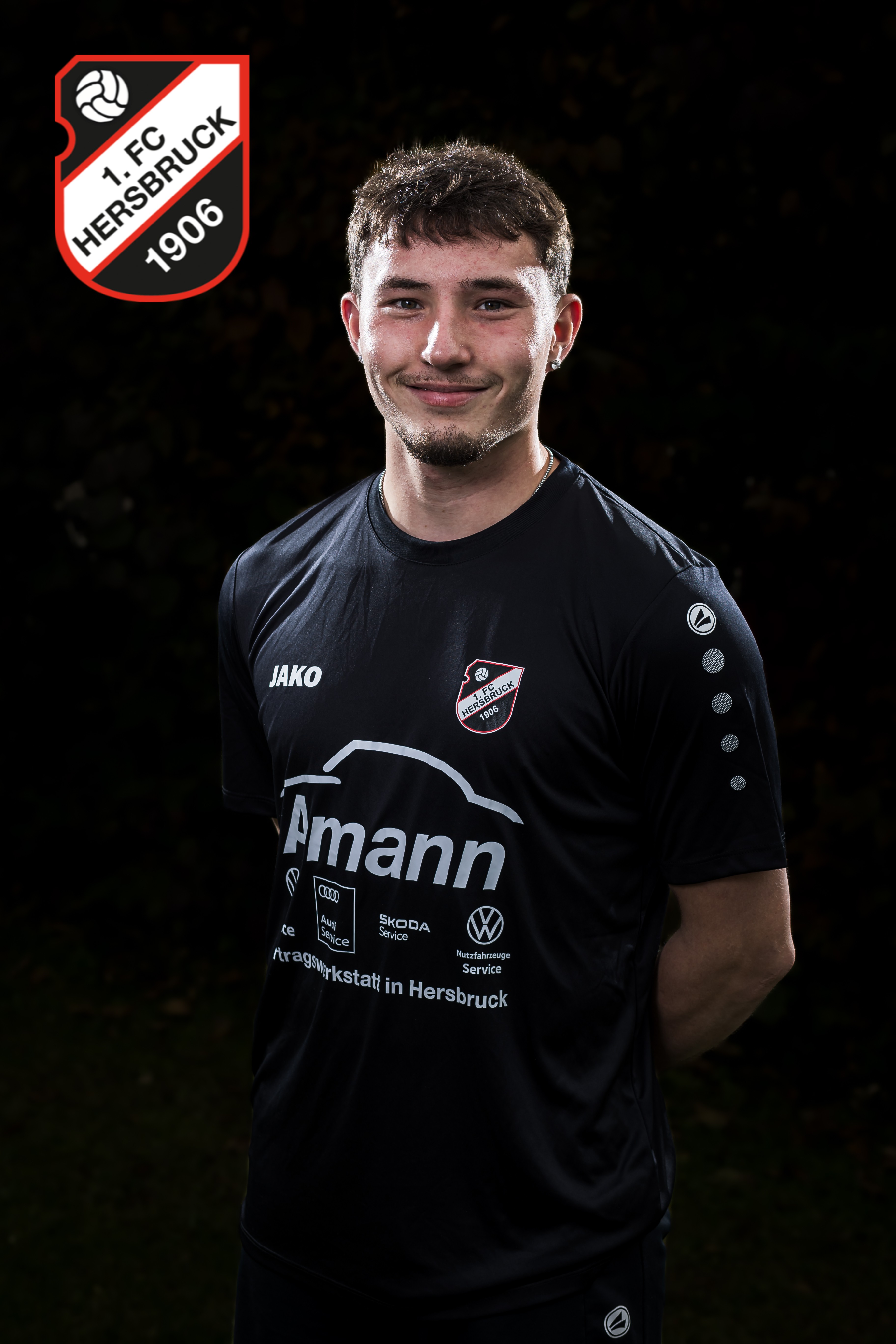 Fußballspieler des 1. FC Hersbruck 1906 im schwarzen JAKO-Trikot mit Amann-Werbung