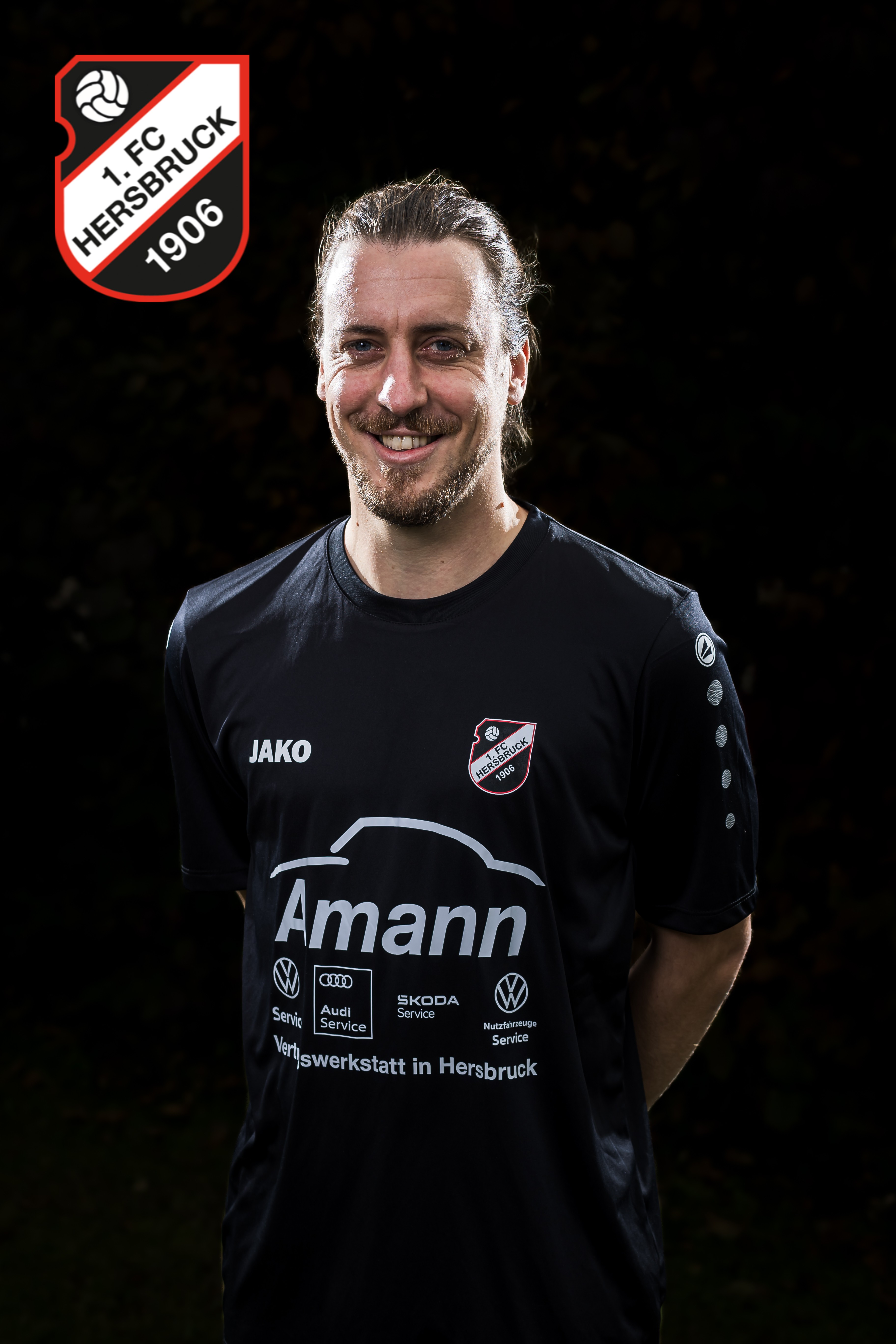 Fußballspieler des 1. FC Hersbruck 1906 im schwarzen JAKO-Trikot mit Amann-Werbung