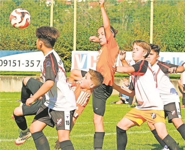Jugendfußballspiel auf dem Rasen, mehrere junge Spieler kämpfen um den Ball