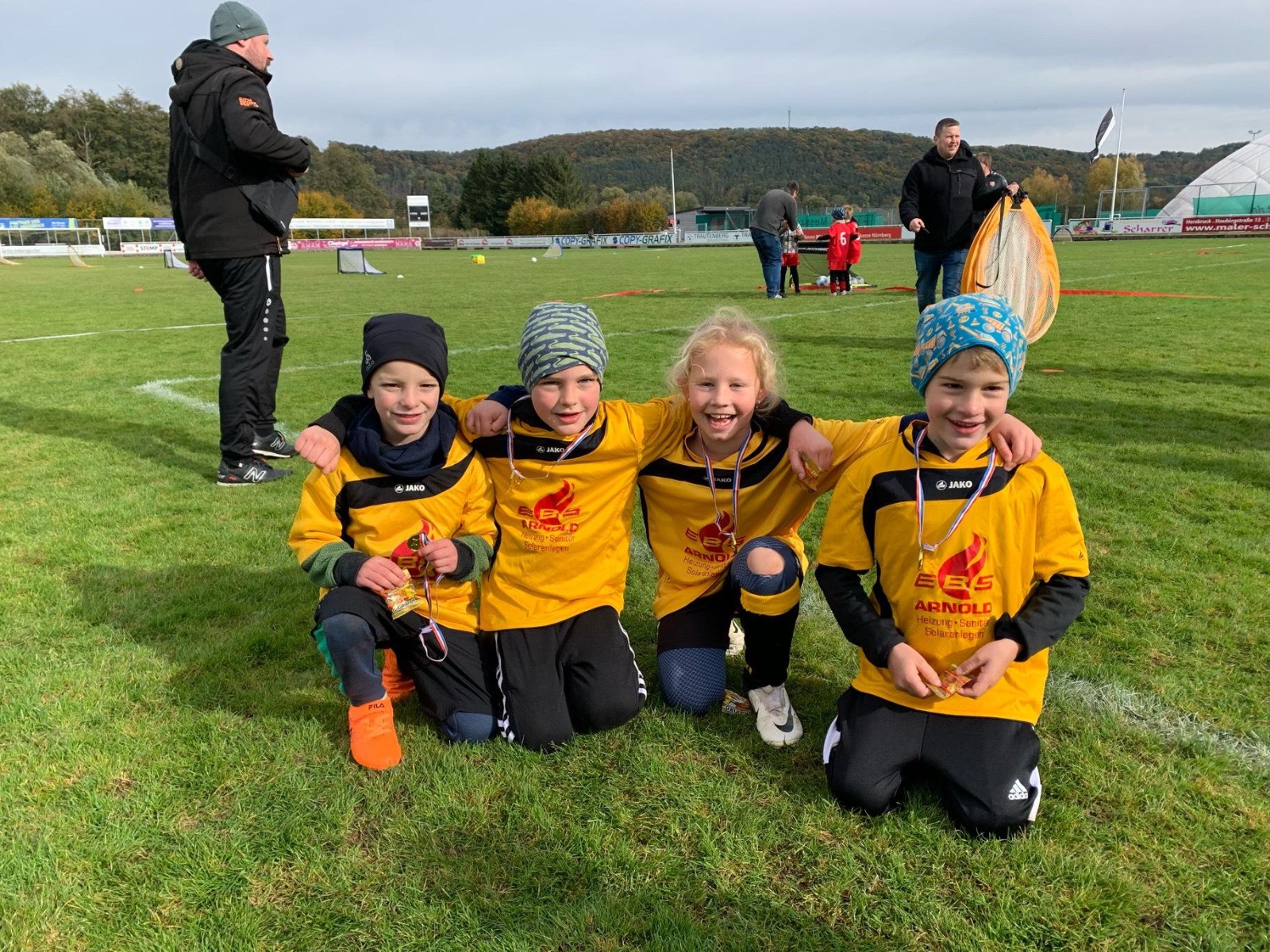 Kinder-Fußballmannschaft mit gelben Trikots bei einem Jugendturnier auf dem Sportplatz