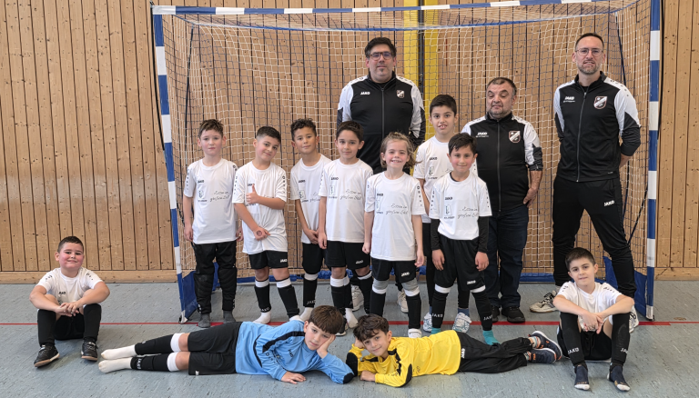 Kinderfußballmannschaft und Trainer in einer Sporthalle vor einem Tor am 01.01.2026