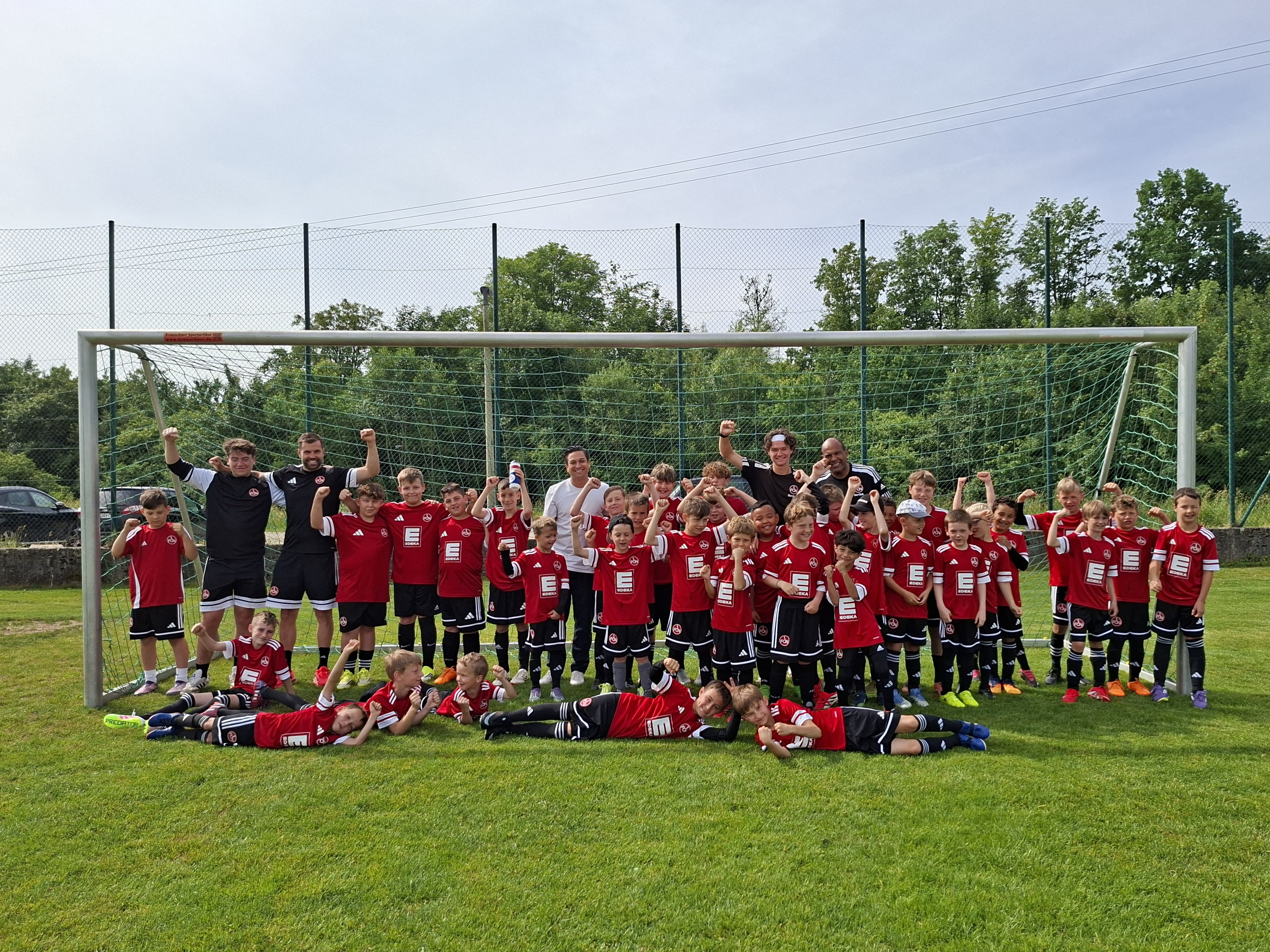 Gruppenfoto einer Jugendfußballmannschaft mit Trainern auf dem Sportplatz am 02.06.2026