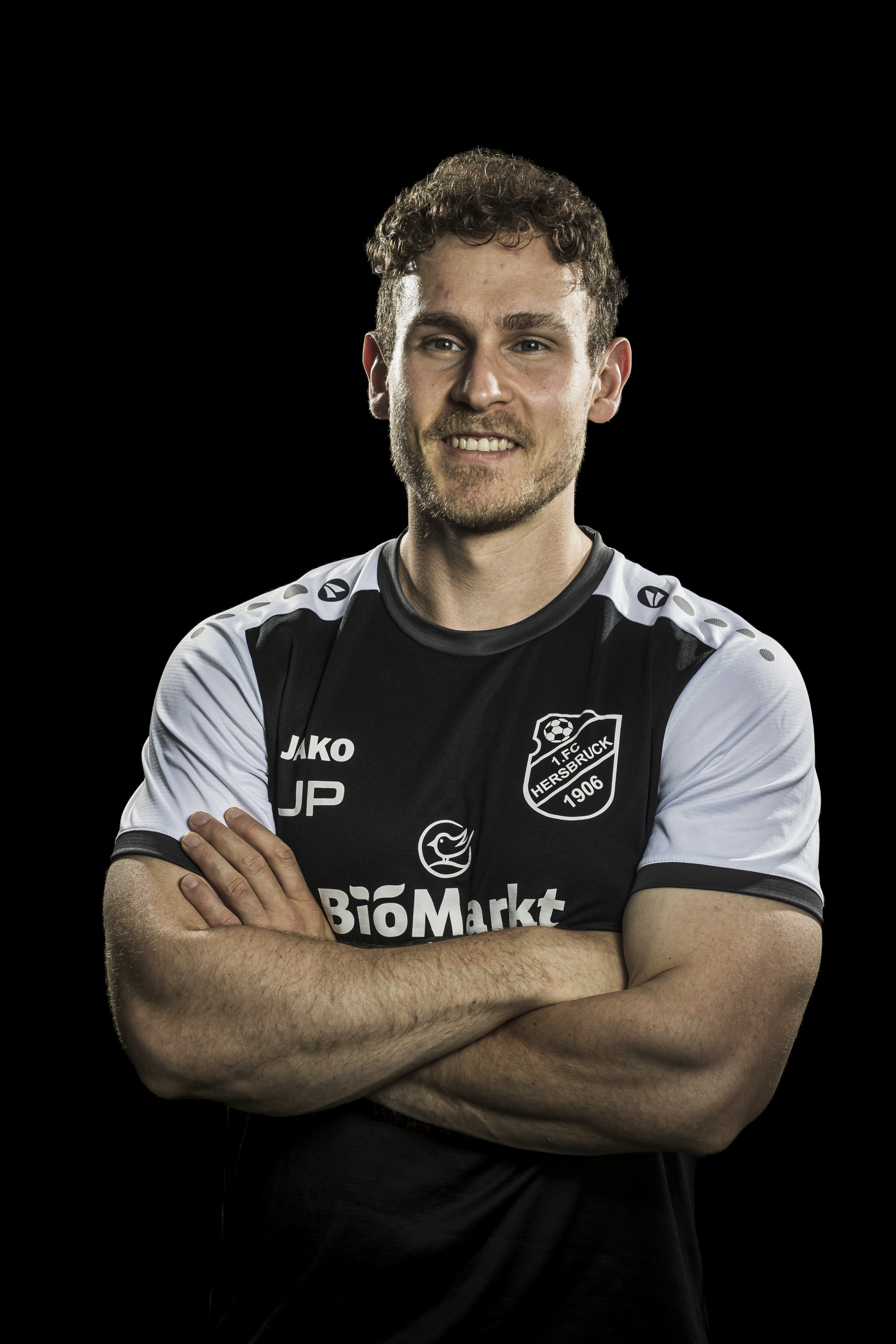 Porträt eines Fußballspielers des 1. FC Hersbruck 1906 im Trikot mit verschränkten Armen