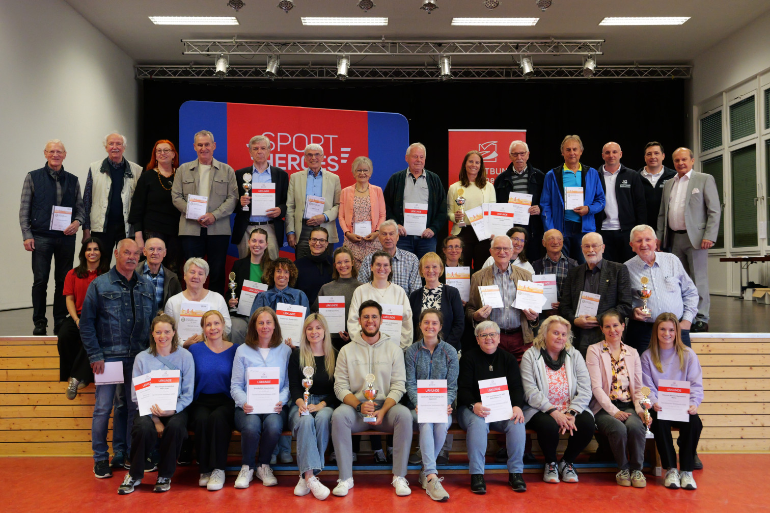 Gruppenfoto von Sportlerinnen und Sportlern bei einer Sport Heroes Ehrung mit Urkunden und Pokalen
