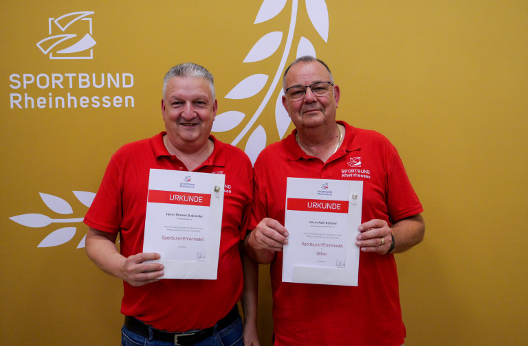 Ehrung beim Sportbund Rheinhessen – Zwei Männer mit Urkunden ausgezeichnet Zwei Männer mit Urkunden bei einer Ehrung des Sportbund Rheinhessen