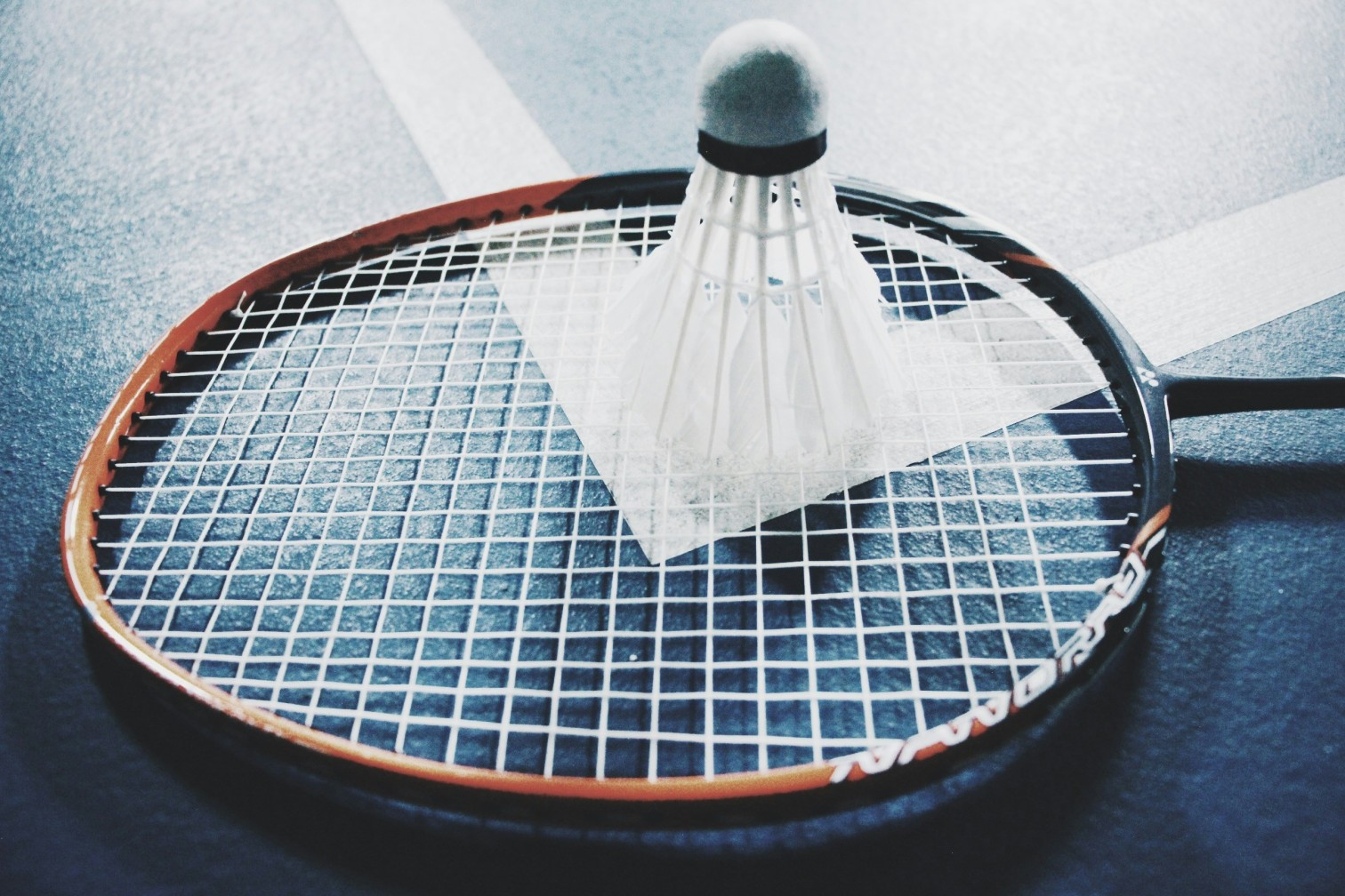 Badmintonschläger mit Shuttlecock auf einem Tennisplatz