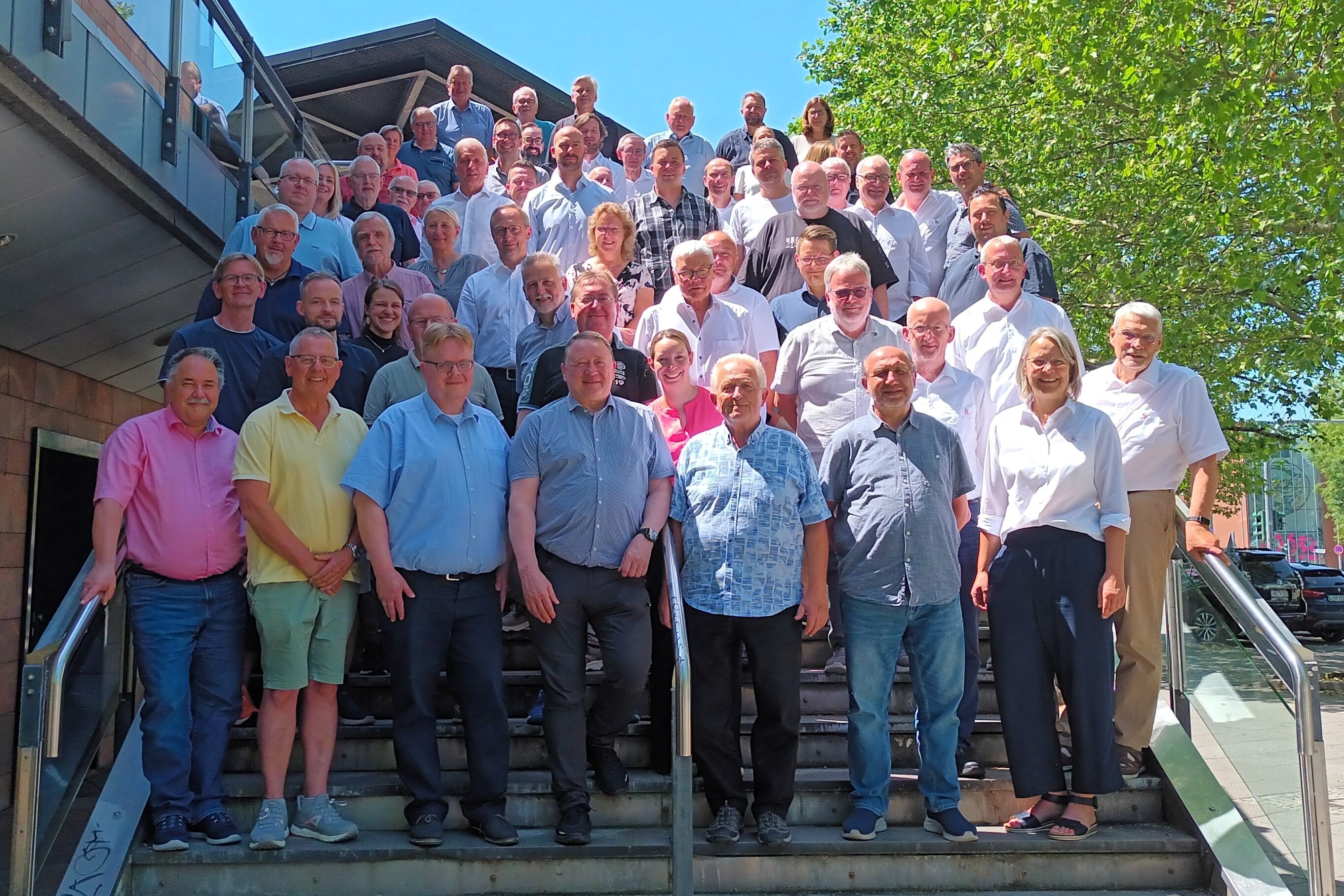 Großes Gruppenfoto von Menschen auf einer TreppeTreppe im Freien