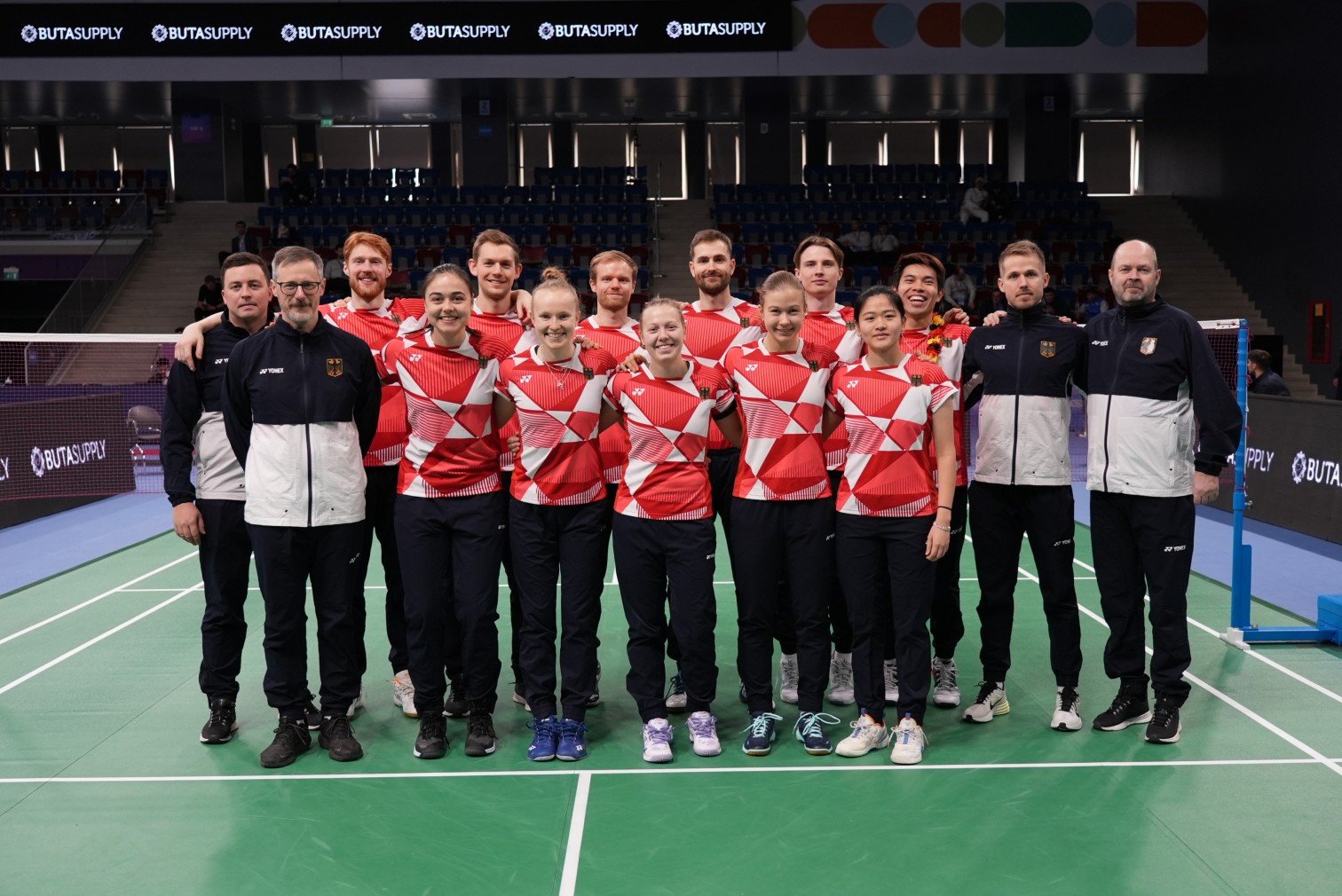 Deutsches Badminton-Team in einheitlicher Sportkleidung auf einem Indoor-Spielfeld