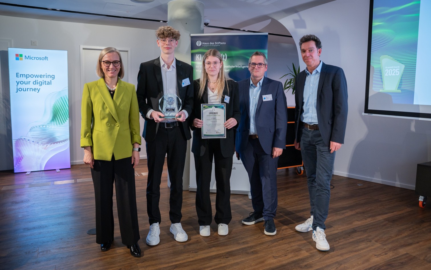 Gruppenfoto bei der Veranstaltung KI vereint am 26.11.2025 in Köln, Teilnehmer mit Urkunde und Auszeichnung