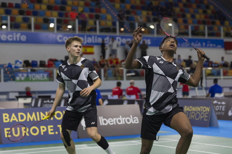 Zwei Badmintonspieler im Doppel bei einem Turnier in einer Sporthalle