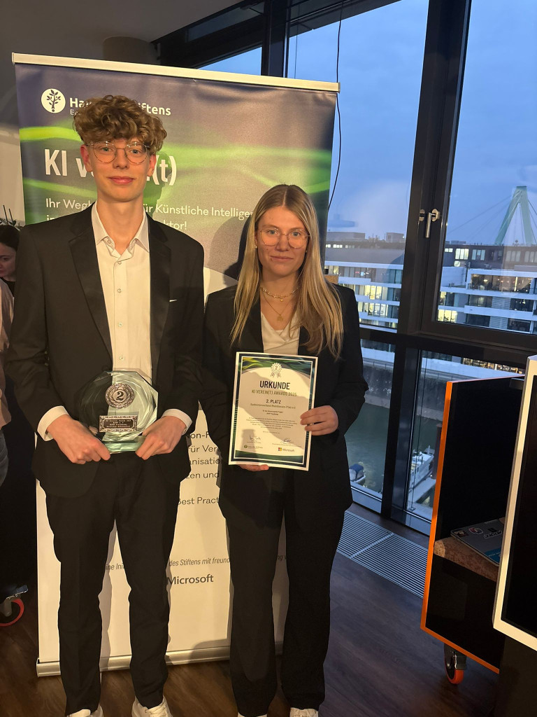 Zwei Personen mit Urkunde und Pokal bei einer KI-Veranstaltung, 2. Platz, Auszeichnung, Microsoft, Abendveranstaltung