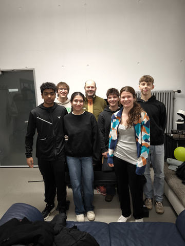 Gruppenbild mit John in einem modernen Raum