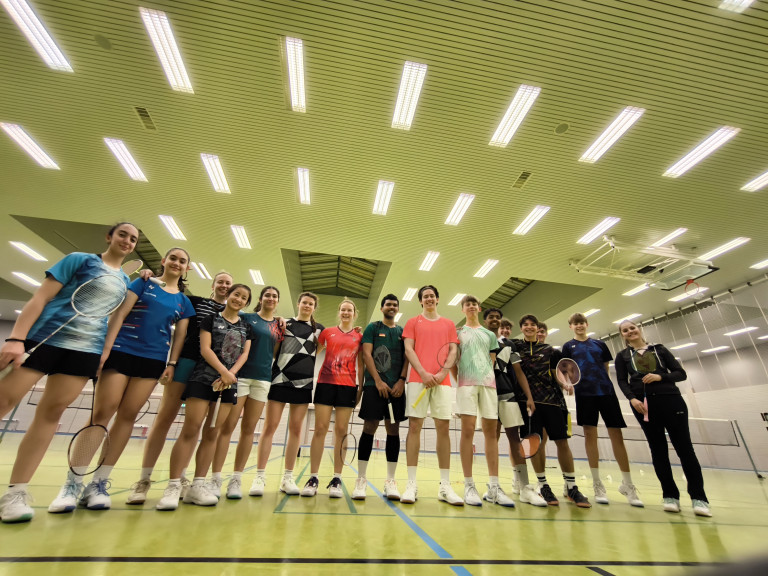 Gruppe von Badmintonspielern in einer Sporthalle