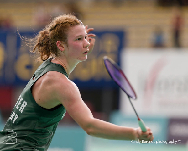 Badmintonspielerin im Spiel mit Schläger in der Hand auf einem Indoor-Court
