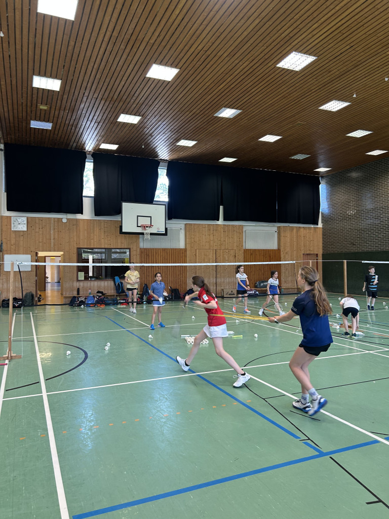 Kinder beim Badminton-Training in einer Sporthalle