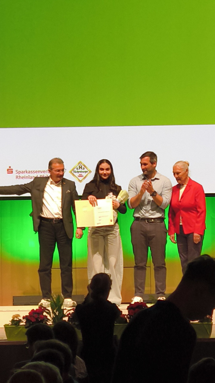 Preisverleihung mit mehreren Personen auf der Bühne, Sparkassenverband Rheinland-Pfalz und Handwerkskammer Logo im Hintergrund